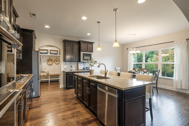 222 Fowler Cir, Franklin, TN 37064 - kitchen with stainless steel appliances, arched walkways, a breakfast bar, a chandelier, and recessed lighting