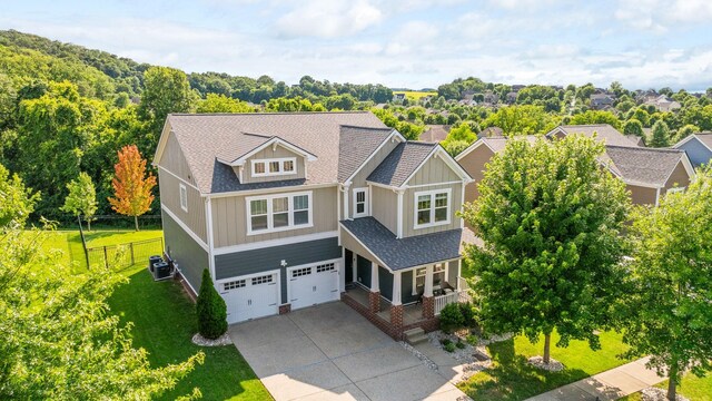 222 Fowler Cir, Franklin, TN 37064 - craftsman-style house featuring board and batten siding, concrete driveway, covered porch, and an attached garage