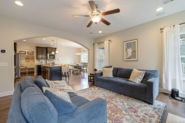 222 Fowler Cir, Franklin, TN 37064 - living room with arched walkways, a ceiling fan, dark wood-style floors, recessed lighting, and a chandelier