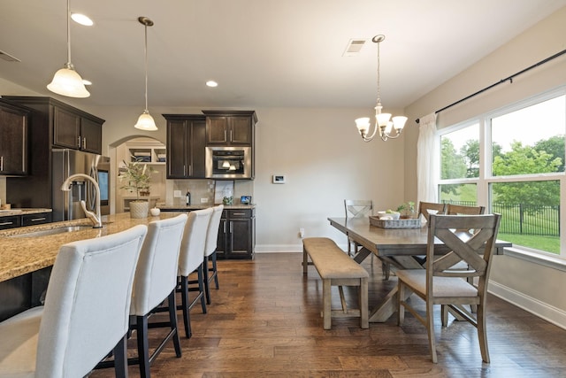 222 Fowler Cir, Franklin, TN 37064 - dining space featuring a chandelier, arched walkways, dark wood finished floors, and recessed lighting