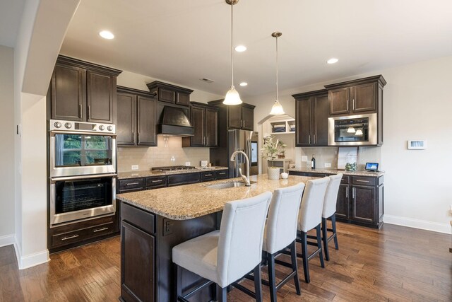 222 Fowler Cir, Franklin, TN 37064 - kitchen with appliances with stainless steel finishes, premium range hood, dark brown cabinets, dark wood finished floors, and recessed lighting