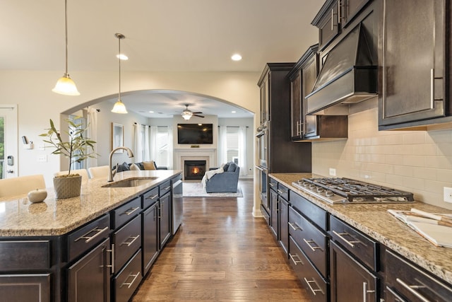 222 Fowler Cir, Franklin, TN 37064 - kitchen with arched walkways, appliances with stainless steel finishes, custom range hood, a ceiling fan, and open floor plan