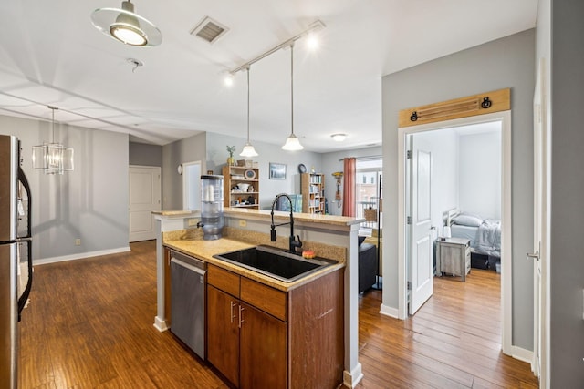 863 Flynn St Unit 302, Chattanooga, TN 37403 - kitchen featuring stainless steel appliances, dark wood finished floors, brown cabinetry, light countertops, and decorative light fixtures