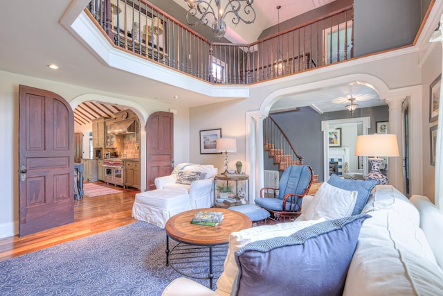 9710 Concord Rd, Brentwood, TN 37027 - living area featuring ornate columns, arched walkways, wood finished floors, stairs, and a high ceiling
