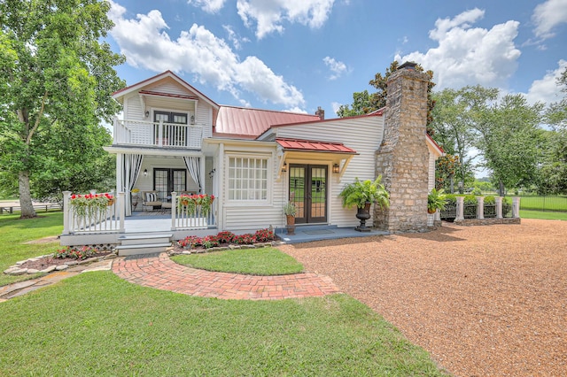9710 Concord Rd, Brentwood, TN 37027 - view of front of house with french doors, covered porch, a front yard, a metal roof, and a balcony