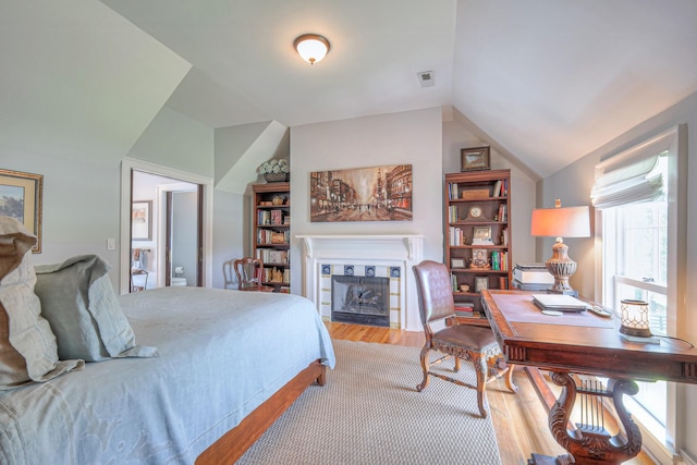 9710 Concord Rd, Brentwood, TN 37027 - bedroom featuring vaulted ceiling, wood finished floors, a tiled fireplace, and a desk