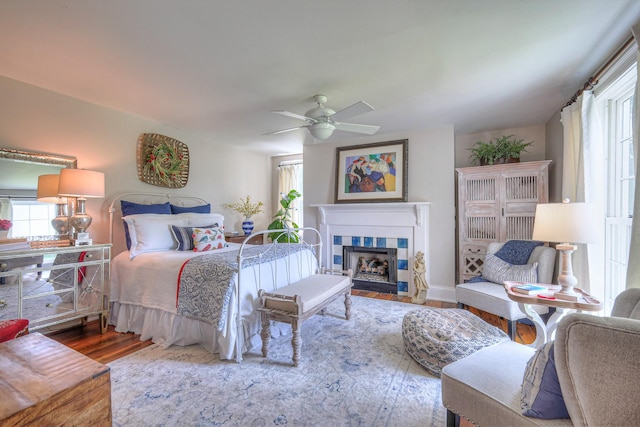 9710 Concord Rd, Brentwood, TN 37027 - bedroom with multiple windows, wood finished floors, a fireplace, and a ceiling fan