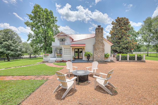 9710 Concord Rd, Brentwood, TN 37027 - rear view of house featuring french doors, an outdoor fire pit, a balcony, a chimney, and a metal roof