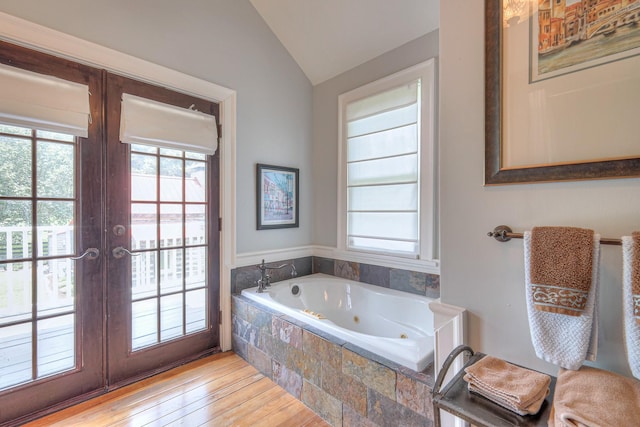 9710 Concord Rd, Brentwood, TN 37027 - bathroom with plenty of natural light, a tub with jets, vaulted ceiling, french doors, and hardwood / wood-style floors