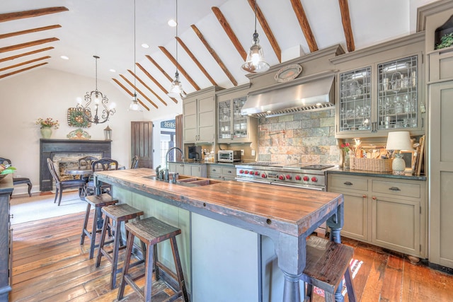9710 Concord Rd, Brentwood, TN 37027 - kitchen featuring wooden counters, lofted ceiling, wall chimney range hood, tasteful backsplash, and a kitchen breakfast bar