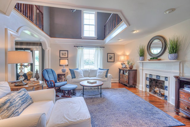 9710 Concord Rd, Brentwood, TN 37027 - living room with decorative columns, wood finished floors, a fireplace with flush hearth, and a towering ceiling