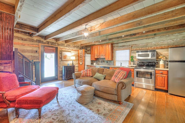 9710 Concord Rd, Brentwood, TN 37027 - living area with plenty of natural light, a wooden ceiling with exposed beams, light wood-type flooring, wood walls, and stairs