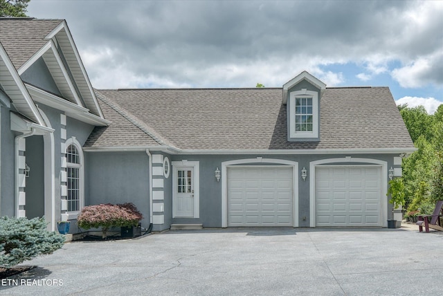 145 Pineridge Loop, Crossville, TN 38558 - view of front facade with stucco siding, a shingled roof, concrete driveway, and a garage