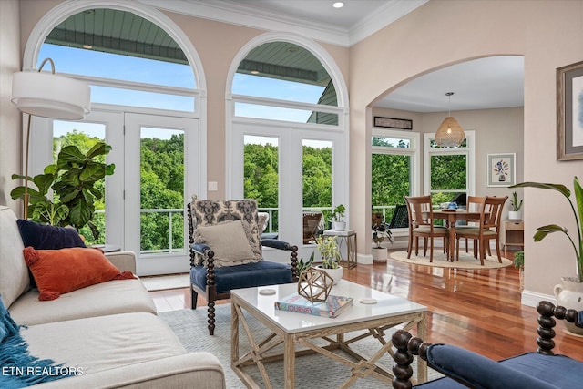 145 Pineridge Loop, Crossville, TN 38558 - living area featuring arched walkways, healthy amount of natural light, wood finished floors, and crown molding