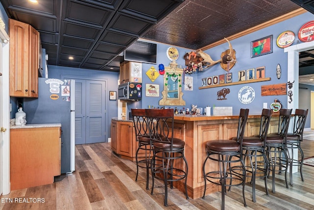 145 Pineridge Loop, Crossville, TN 38558 - indoor dry bar featuring an ornate ceiling, stainless steel microwave, wood finished floors, freestanding refrigerator, and ornamental molding