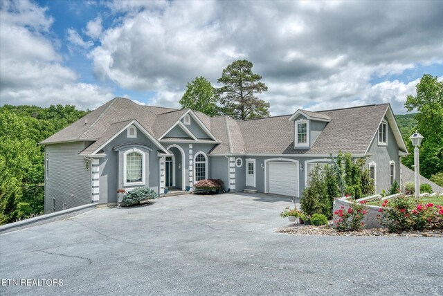 145 Pineridge Loop, Crossville, TN 38558 - view of front of home with driveway, an attached garage, a shingled roof, and stucco siding