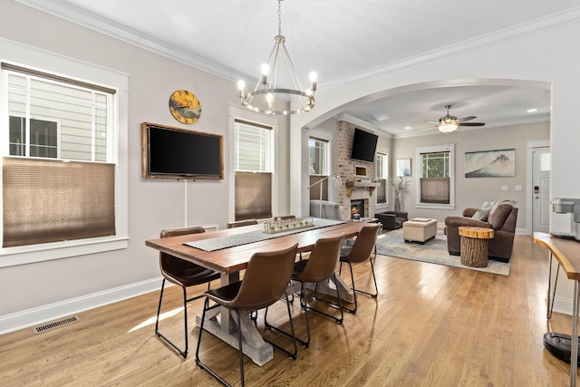 4252 Inlet Loop, Chattanooga, TN 37416 - dining area with a fireplace, light wood-style flooring, a ceiling fan, arched walkways, and crown molding