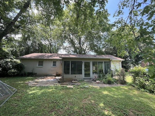 1465 Old Farmington Rd, Lewisburg, TN 37091 - rear view of house featuring a sunroom, brick siding, a lawn, and a patio area