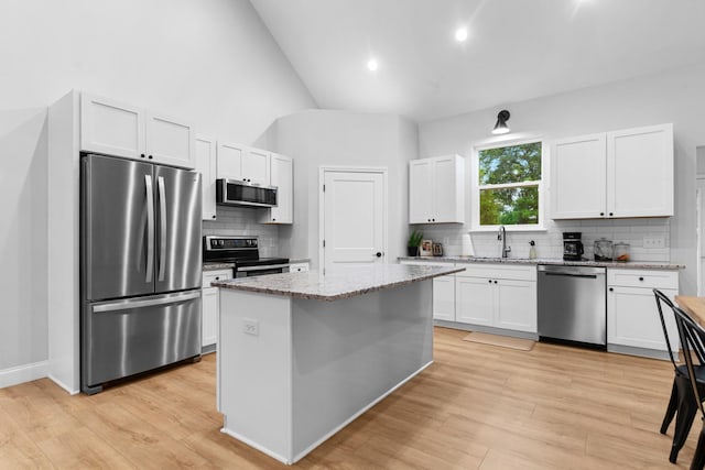 5283 Eagleville Pike, Eagleville, TN 37060 - kitchen featuring stainless steel appliances, backsplash, white cabinetry, light stone counters, and a center island