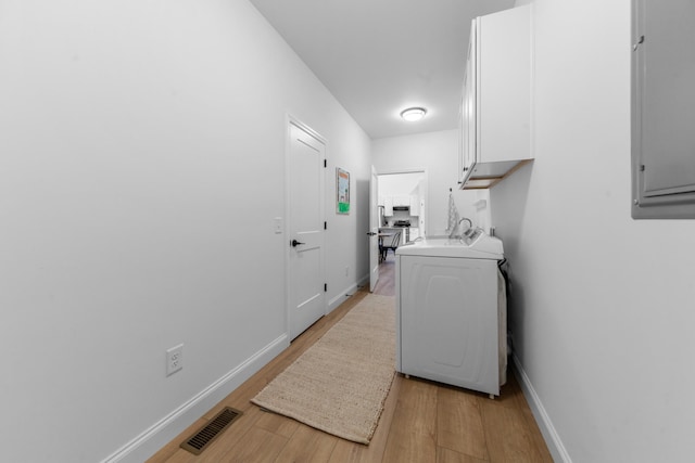 5283 Eagleville Pike, Eagleville, TN 37060 - laundry room with washer / clothes dryer, cabinet space, light wood-type flooring, and electric panel