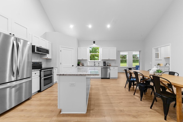 5283 Eagleville Pike, Eagleville, TN 37060 - kitchen featuring stainless steel appliances, backsplash, white cabinetry, a center island, and high vaulted ceiling