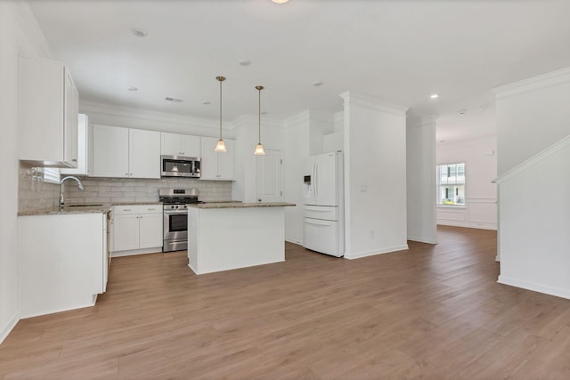 534 Morgan Meadows Way, Columbia, TN 38401 - kitchen featuring appliances with stainless steel finishes, a center island, tasteful backsplash, light stone countertops, and white cabinets