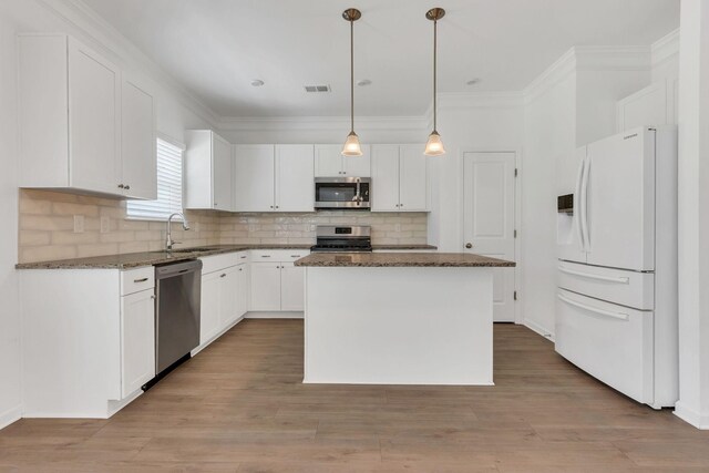 534 Morgan Meadows Way, Columbia, TN 38401 - kitchen with appliances with stainless steel finishes, dark stone countertops, backsplash, white cabinetry, and a center island
