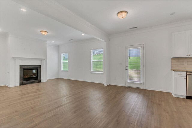 534 Morgan Meadows Way, Columbia, TN 38401 - unfurnished living room featuring crown molding, light wood-style floors, a glass covered fireplace, and recessed lighting