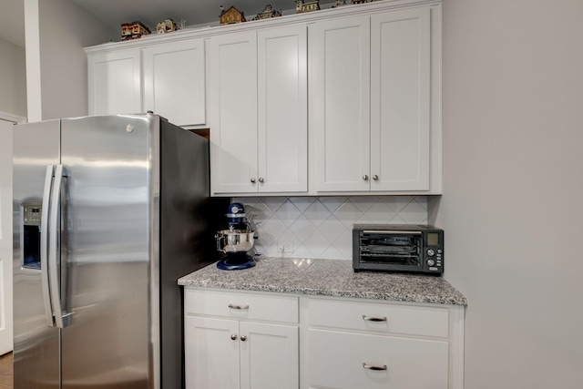 907 Nance Ln, Lebanon, TN 37087 - kitchen with stainless steel fridge, decorative backsplash, white cabinets, and light stone counters