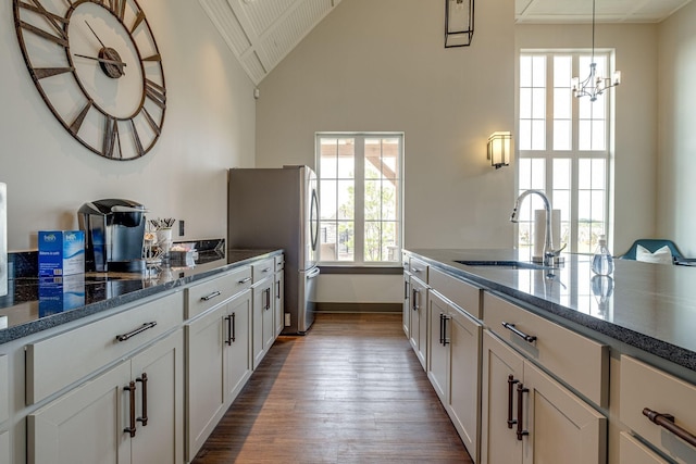 907 Nance Ln, Lebanon, TN 37087 - kitchen featuring dark wood-style flooring, freestanding refrigerator, lofted ceiling, a chandelier, and dark stone countertops