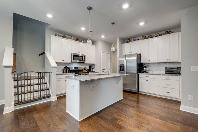 907 Nance Ln, Lebanon, TN 37087 - kitchen with appliances with stainless steel finishes, decorative backsplash, dark wood-style flooring, white cabinets, and a center island with sink