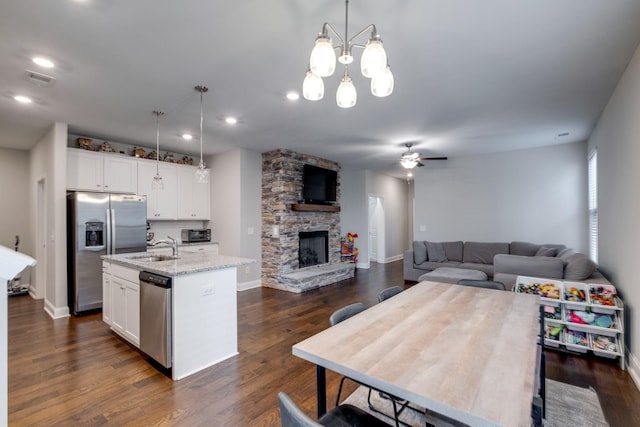 907 Nance Ln, Lebanon, TN 37087 - kitchen featuring stainless steel appliances, a stone fireplace, a kitchen island with sink, ceiling fan, and white cabinetry
