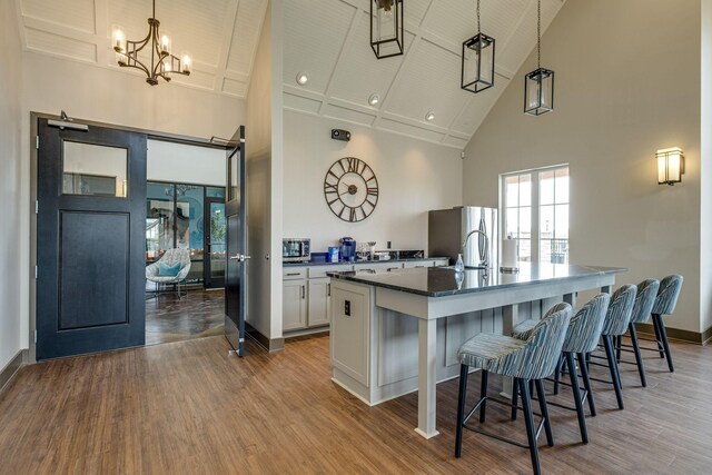 907 Nance Ln, Lebanon, TN 37087 - kitchen with high vaulted ceiling, freestanding refrigerator, a chandelier, a kitchen island with sink, and wood finished floors
