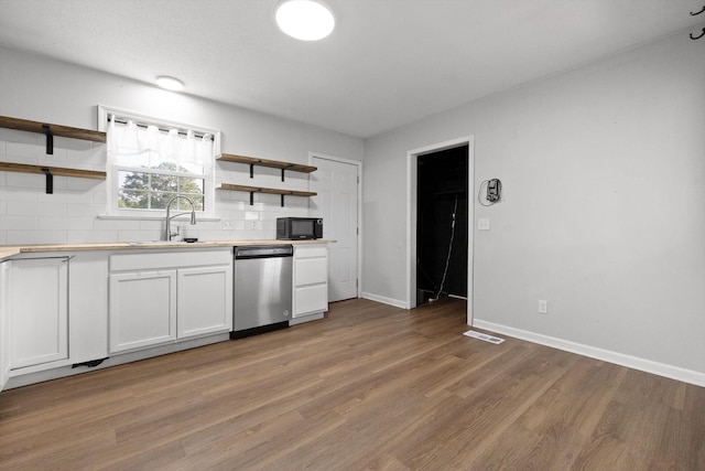 4726 Tarpon Trl, Chattanooga, TN 37416 - kitchen featuring stainless steel dishwasher, open shelves, black microwave, white cabinetry, and wood finished floors