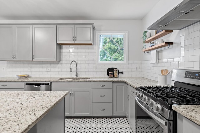 225 Hemphill Ave, Chattanooga, TN 37411 - kitchen featuring stainless steel appliances, wall chimney range hood, gray cabinets, open shelves, and tasteful backsplash