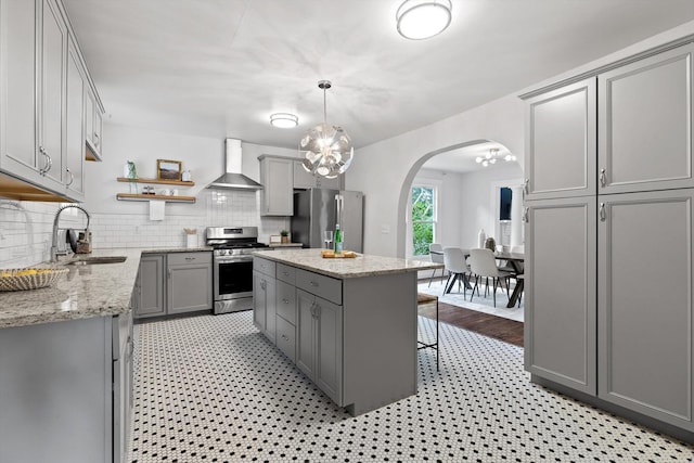 225 Hemphill Ave, Chattanooga, TN 37411 - kitchen with appliances with stainless steel finishes, gray cabinets, wall chimney range hood, and arched walkways