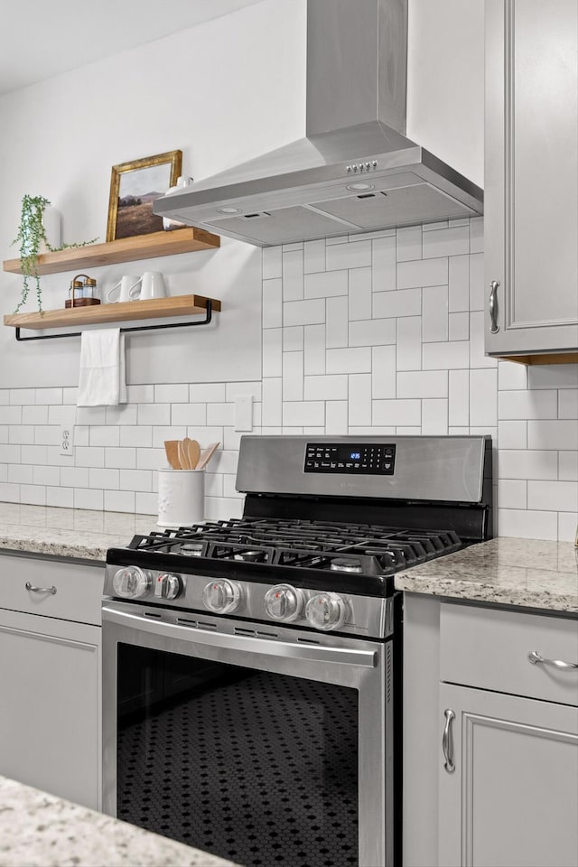 225 Hemphill Ave, Chattanooga, TN 37411 - kitchen featuring wall chimney range hood, stainless steel gas stove, open shelves, tasteful backsplash, and light stone counters