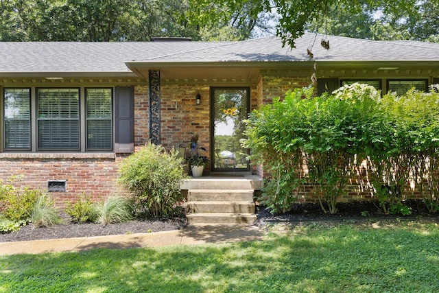 5033 Ragland Dr, Nashville, TN 37220 - view of exterior entry featuring brick siding, a shingled roof, and a lawn