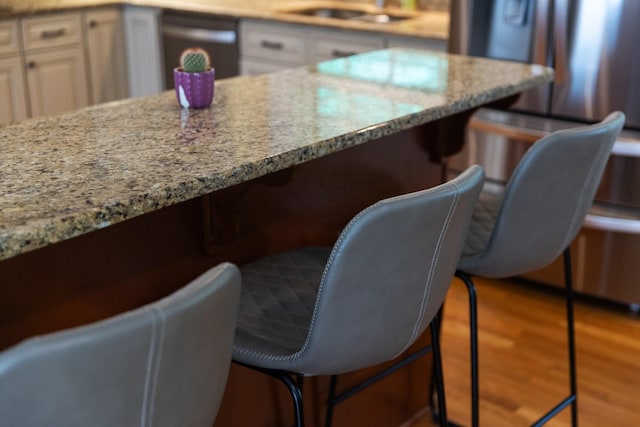 5033 Ragland Dr, Nashville, TN 37220 - kitchen with light stone countertops, a breakfast bar, and wood finished floors