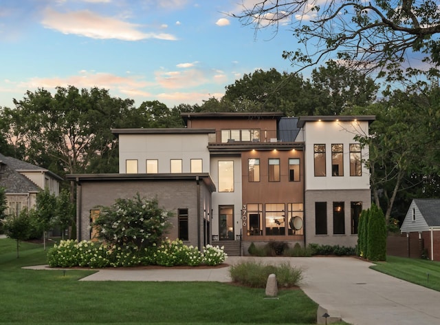 3706 Benham Ave, Nashville, TN 37215 - back of property at dusk with stucco siding, a lawn, and brick siding