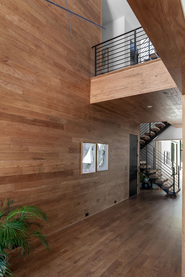 3706 Benham Ave, Nashville, TN 37215 - unfurnished living room with wood walls, wood finished floors, stairs, and a towering ceiling