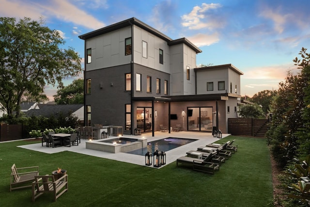 3706 Benham Ave, Nashville, TN 37215 - back of house at dusk featuring a fire pit, a patio area, and a pool with connected hot tub