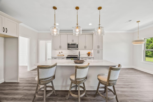 200 Creekside Dr, Lewisburg, TN 37091 - kitchen with stainless steel appliances, ornamental molding, backsplash, wood finished floors, and a kitchen island with sink