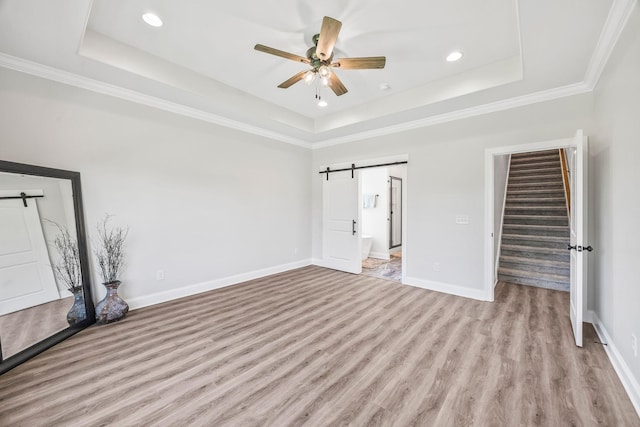 200 Creekside Dr, Lewisburg, TN 37091 - unfurnished bedroom featuring a barn door, a raised ceiling, light wood-style flooring, recessed lighting, and ornamental molding