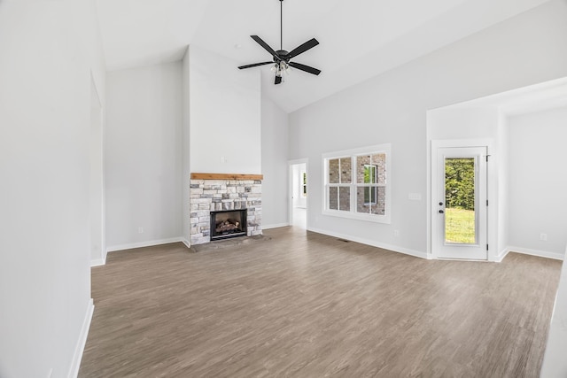 198 Creekside Dr, Lewisburg, TN 37091 - unfurnished living room with high vaulted ceiling, wood finished floors, a stone fireplace, and ceiling fan