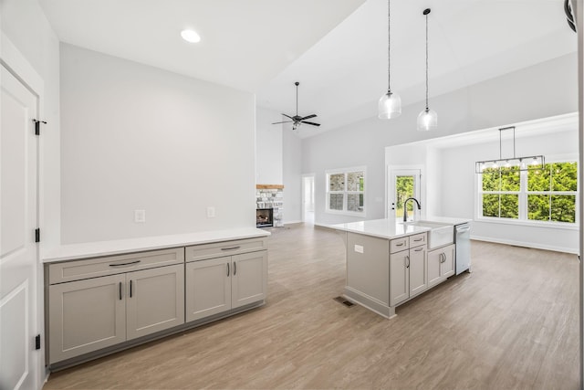 198 Creekside Dr, Lewisburg, TN 37091 - kitchen featuring ceiling fan, stainless steel dishwasher, a fireplace, gray cabinetry, and light countertops