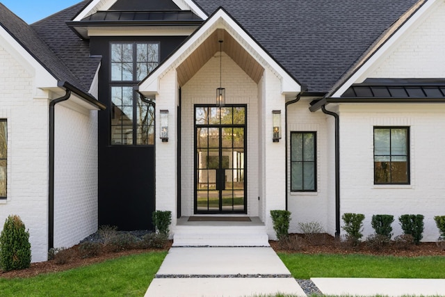 3037 Lakeshore Dr, Old Hickory, TN 37138 - view of exterior entry featuring a standing seam roof, brick siding, a shingled roof, and a metal roof