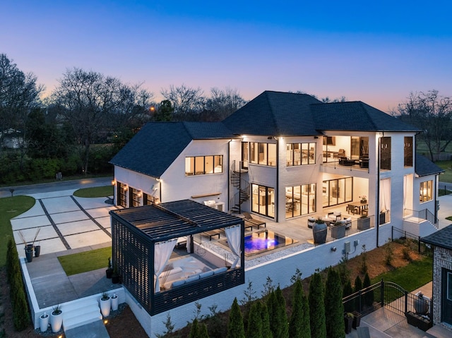 3037 Lakeshore Dr, Old Hickory, TN 37138 - back of house at dusk featuring a balcony, stairs, roof with shingles, and stucco siding