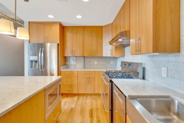417 Frazier Ave Unit 404, Chattanooga, TN 37405 - kitchen with stainless steel appliances, exhaust hood, light stone countertops, hanging light fixtures, and recessed lighting