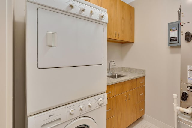 417 Frazier Ave Unit 404, Chattanooga, TN 37405 - laundry room with estacked washer and dryer, cabinet space, light tile patterned floors, and bar with sink